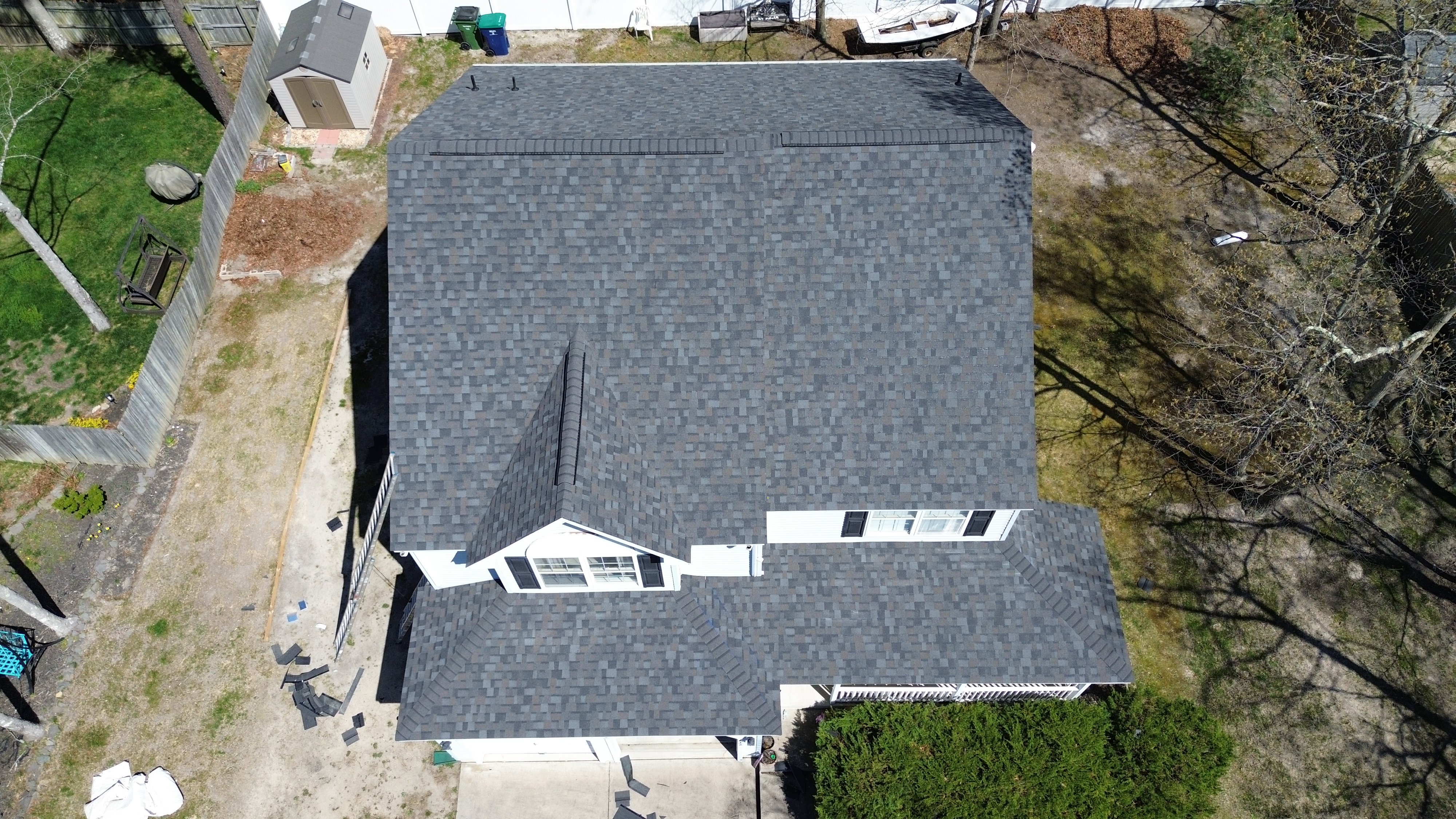 Two roofers working together on residential home roof replacement