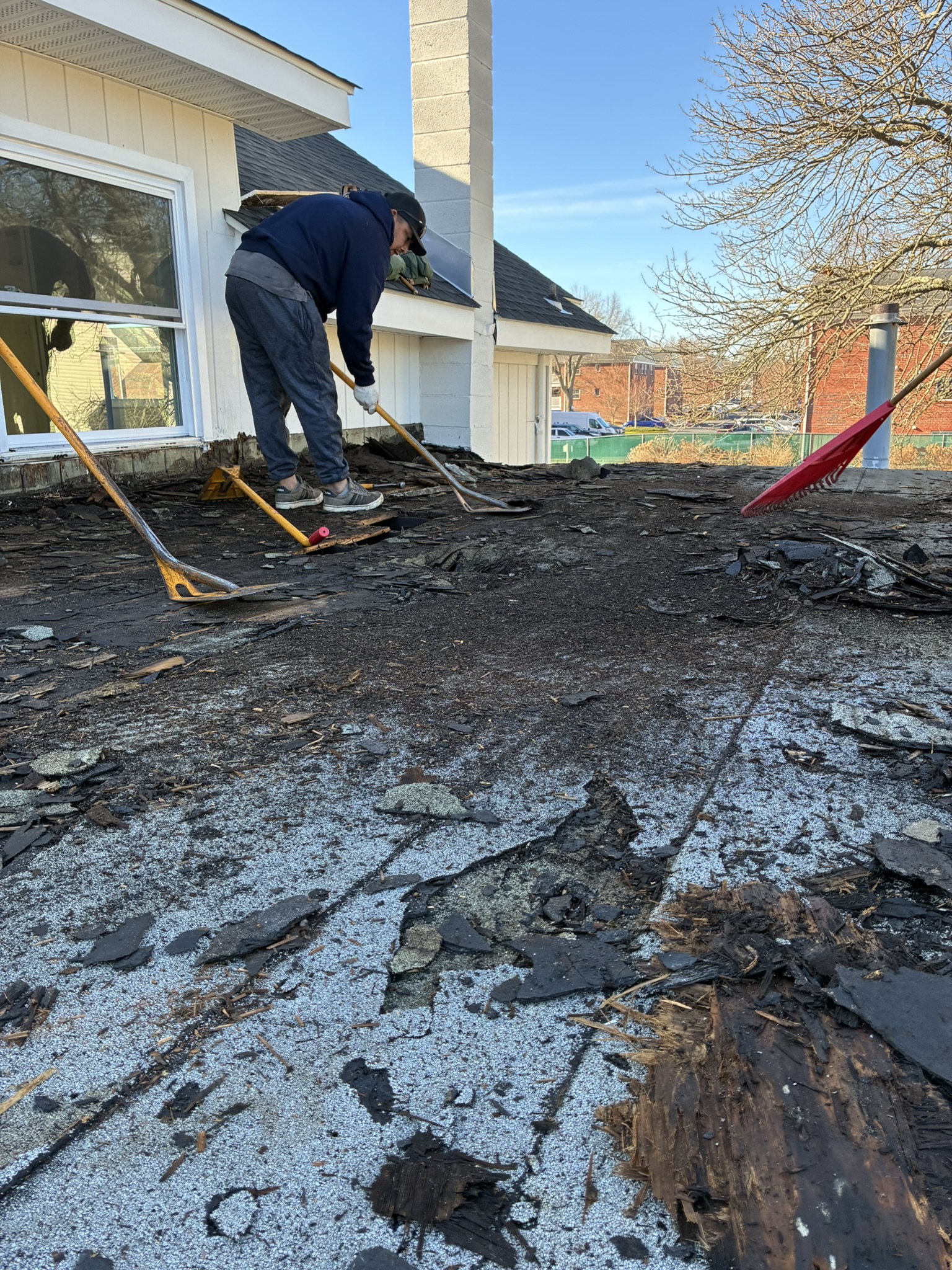 Two roofers making repairs on a residential roof