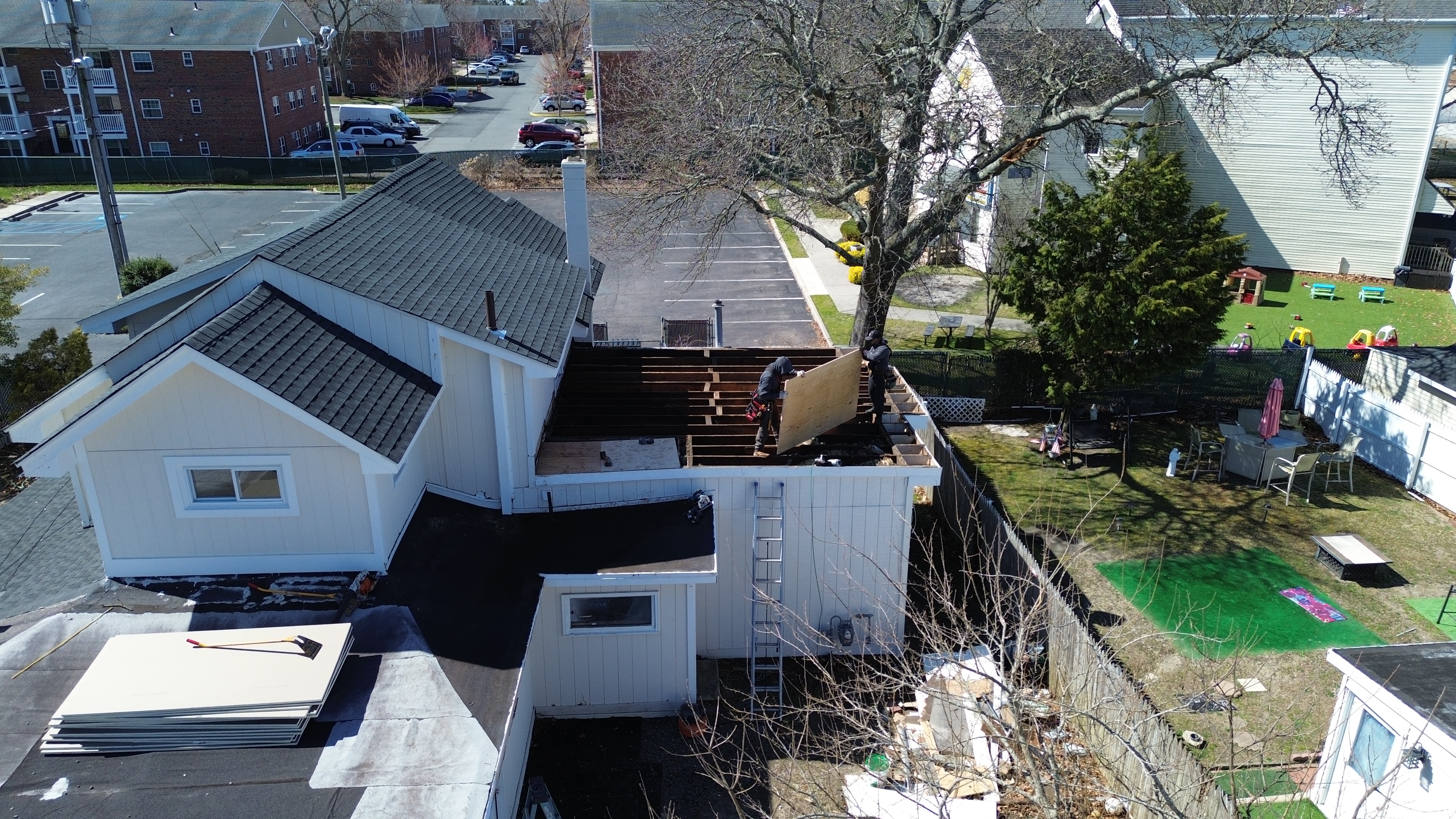 Roofer using a drill to complete a precision roof repair in South Jersey